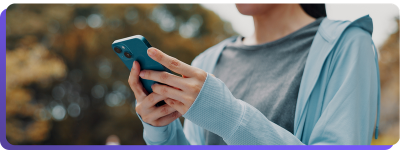 Close up of woman holding phone outside, using wellness app-2
