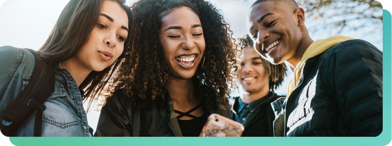 four teens looking at phone