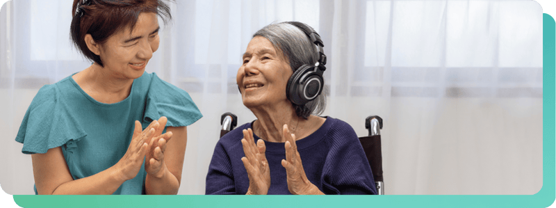 two ladies clapping while one is listening to music
