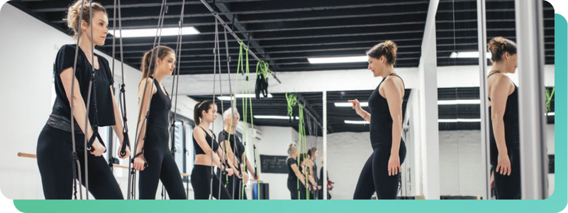 women in a workout class with in instructor while listening to feed originals 